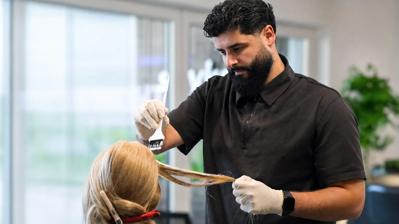Außendienstmitarbeiter Mehmet Sürmeli trägt ColorUp Haarfarbe auf eine blonde Strähne auf